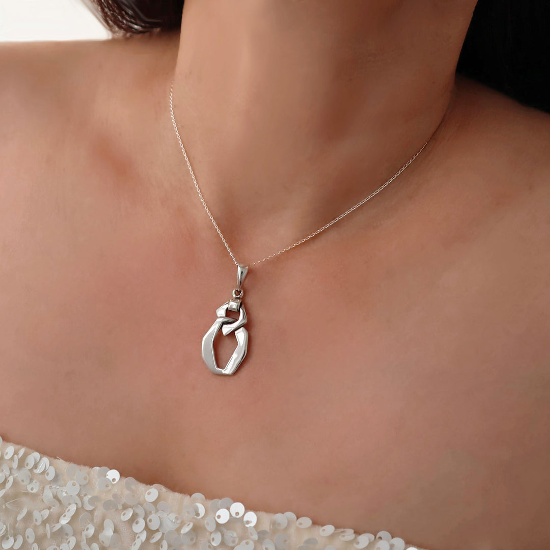Ladies 925 Silver curb link pendant and chain necklace on a woman wearing a white dress.