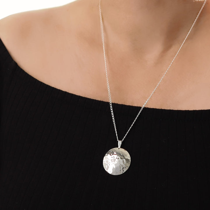 woman in a black top wearing a large hammered circle pendant and chain necklace in 925 sterling silver