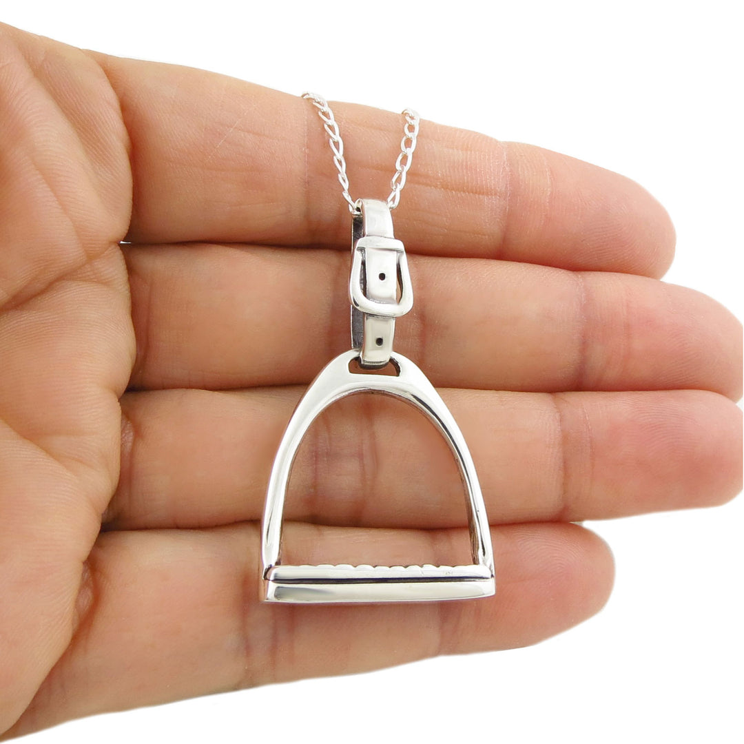 Sterling 925 silver equestrian horse stirrup pendant and chain necklace held in a woman's hand against a white background