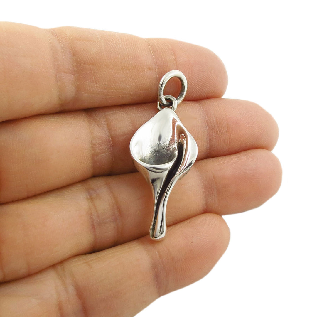 Taxco 925 Silver calla lily flower pendant necklace charm held between fingers on a white background