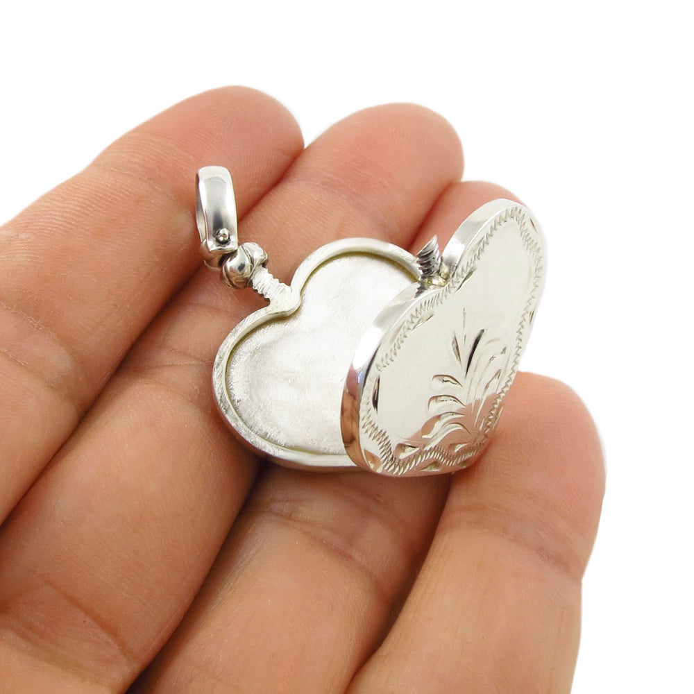925 silver heart-shaped locket style pendant jewellery held in a hand against a white background