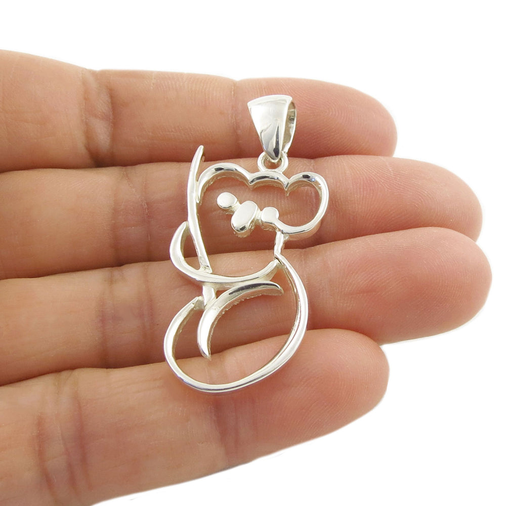 925 sterling silver pendant jewellery shaped like a koala bear held between fingers on a white background