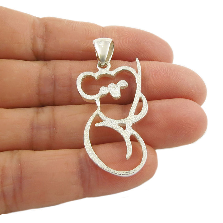 Sterling 925 Silver pendant shaped like a koala bear clutching a bamboo shoot held between fingers on a white background