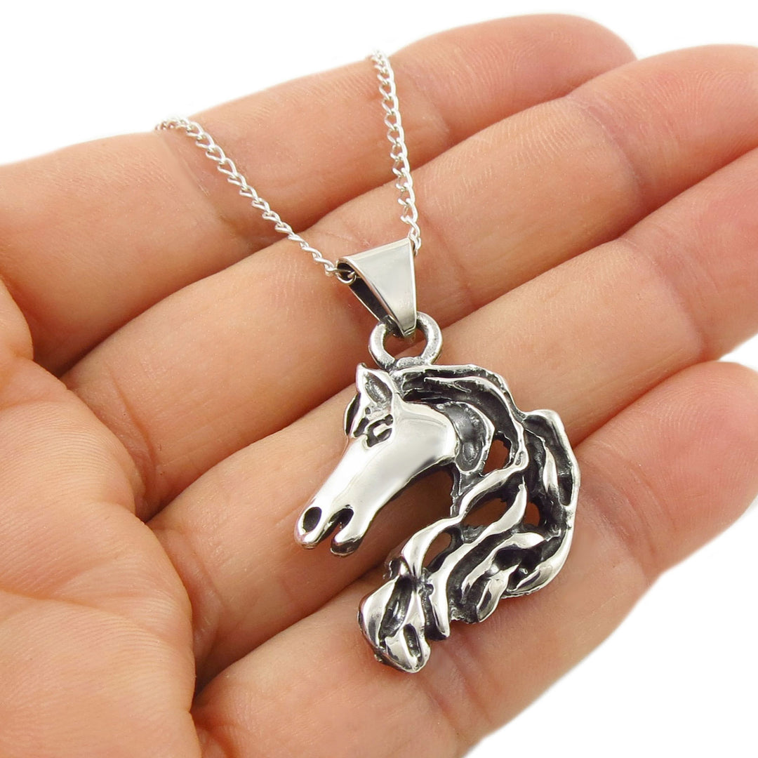Equestrian 925 sterling silver horse pendant necklace held in a hand against a white background