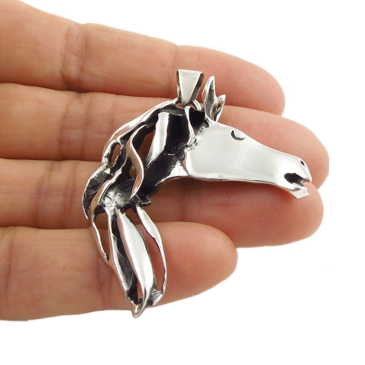Sterling 925 silver equestrian horse pendant necklace held between fingers against a white background