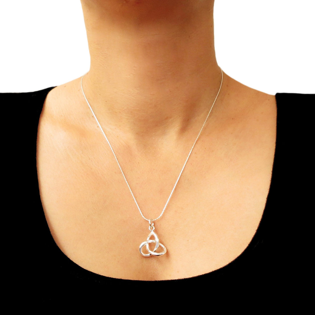 Silver necklace with a Trinity love knot pendant on a woman wearing a black top.