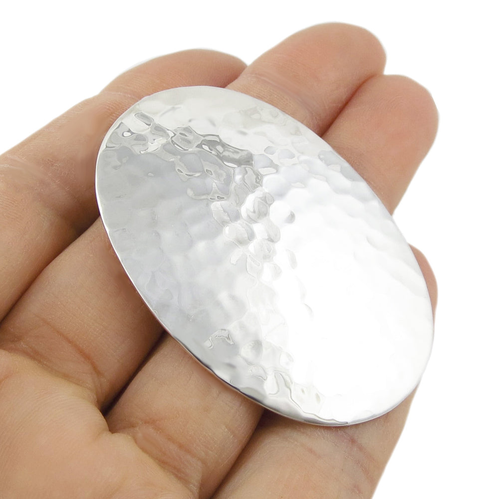 Large handmade sterling 925 silver pendant held in a hand against a white background