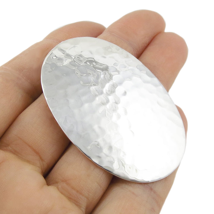 Large handmade sterling 925 silver pendant held in a hand against a white background