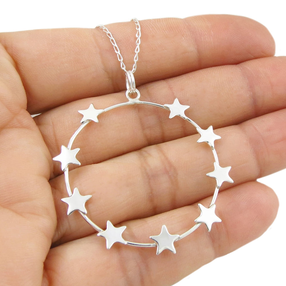 925 silver star-shaped pendant necklace for women held in a hand against a white background