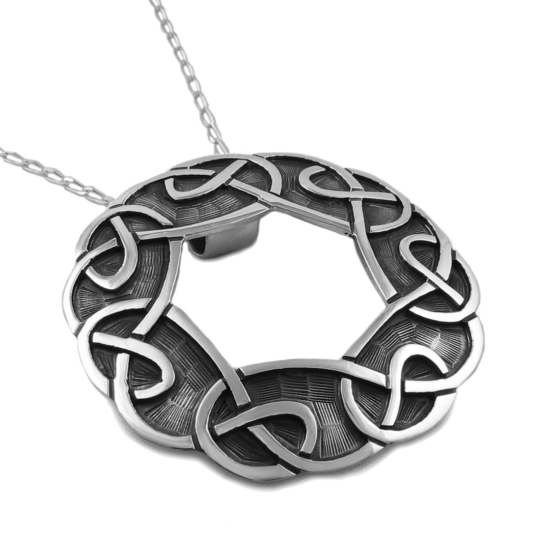 A large 925 sterling silver Celtic love knot pendant necklace on a curb chain necklace, shown against a plain white background.