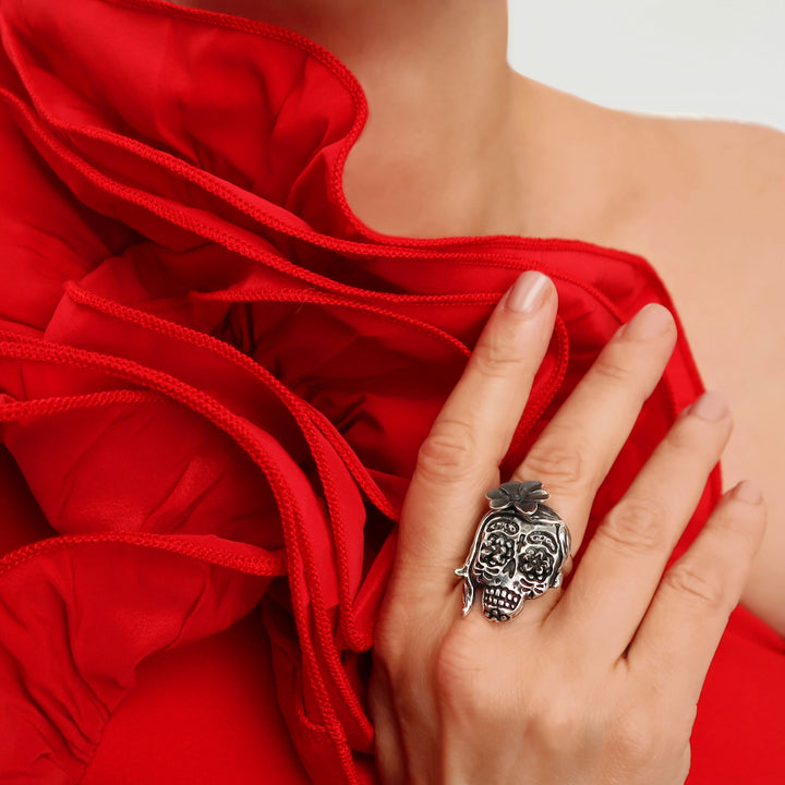A large sterling 925 silver sugar kulll and flowers cocktaill ring worn by a woman in a red dress.