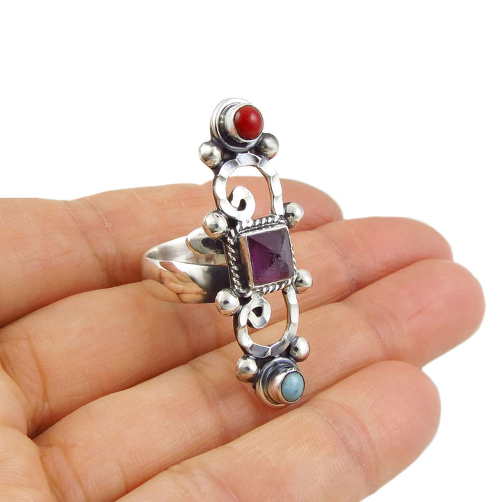 Baroque sterling 925 silver cocktail ring for women with gemstones held in a hand on a white background