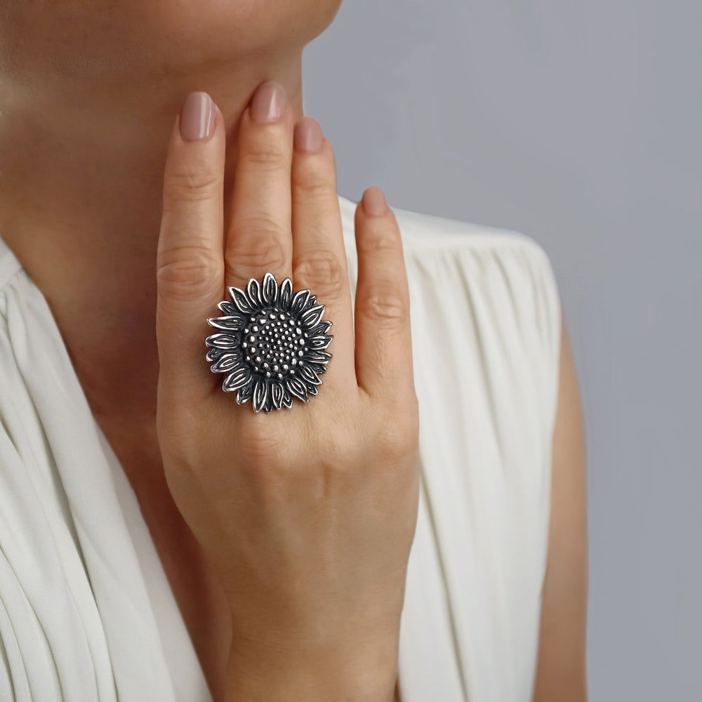 A large 925 sterling silver chunky sunflower ring worn on a woman's hand, with a polished and blackened finish.