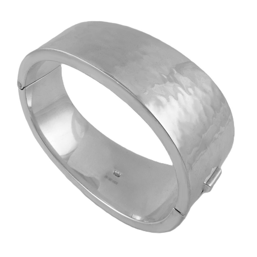 A bold hinged sterling silver cuff bracelet with a hammered finish, displayed against a white background.