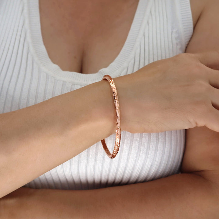 Copper bracelet on a wrist with a white ribbed top