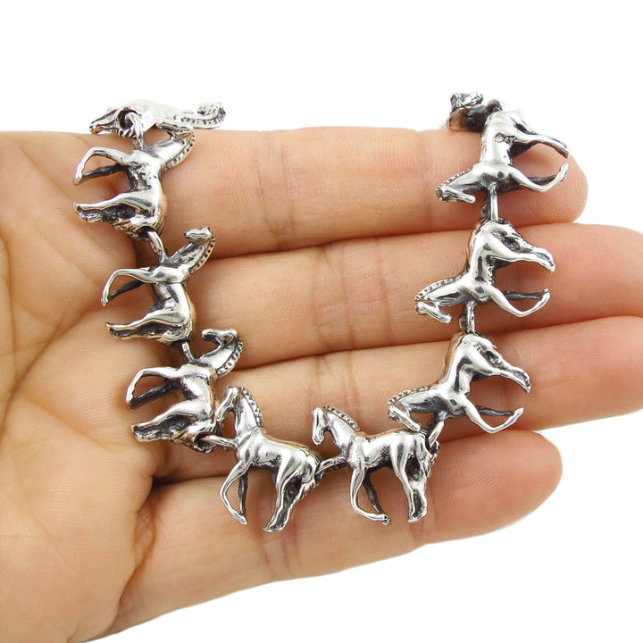 Silver horse-shaped bracelet on a hand with a white background