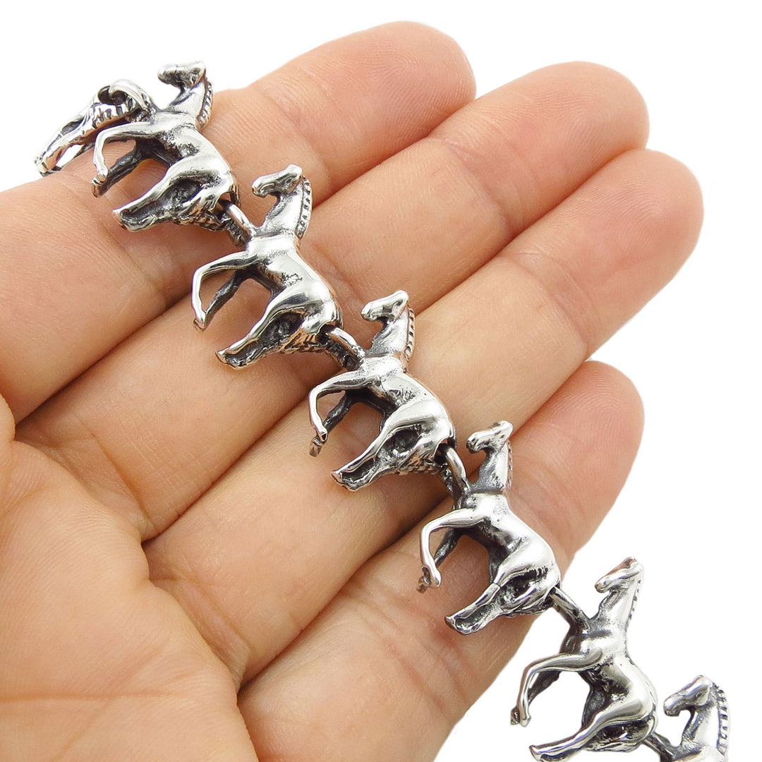 Silver horse-shaped bracelet on a hand with a white background
