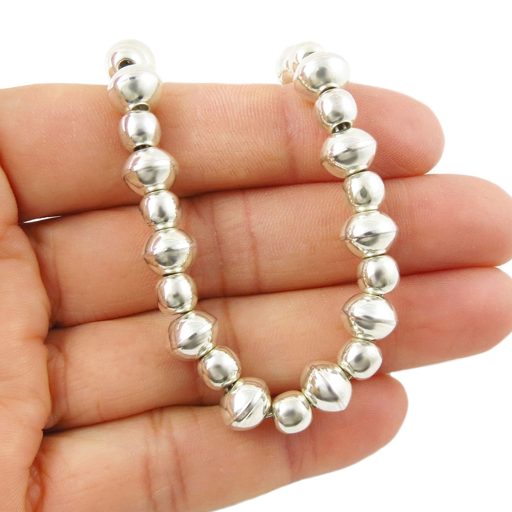 UK sterling 925 Silver beaded bracelet on a hand against a white background