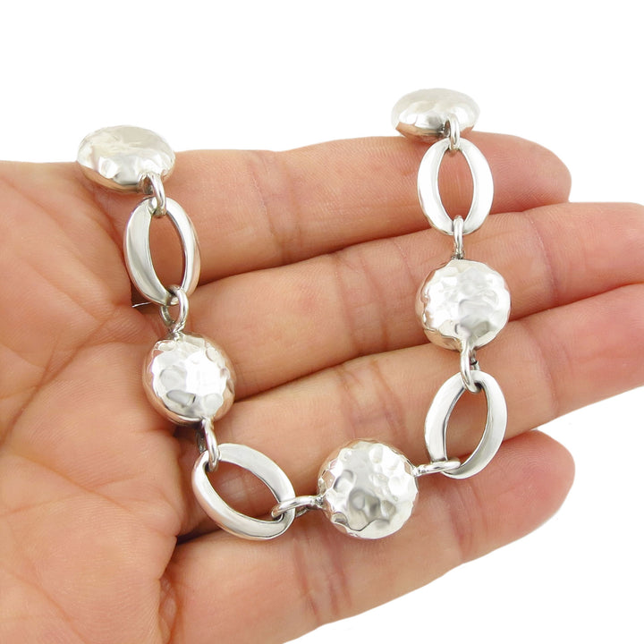 Sterling 925 Silver bracelet for women with round and oval links and a hammered and polished finish held on a hand against a white background