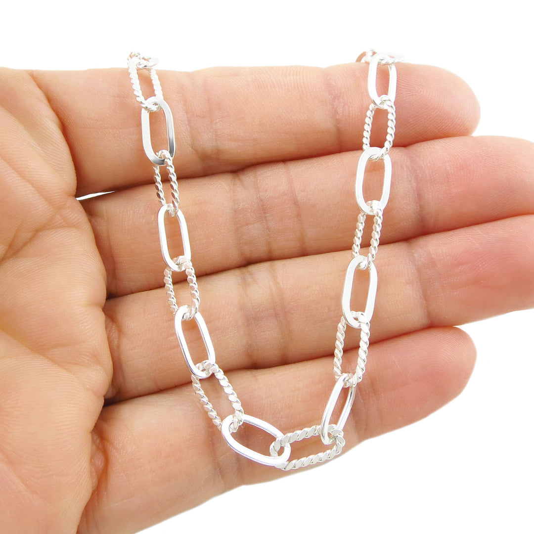 UK 925 sterling Silver solid paperclip chain bracelet held in a hand against a white background