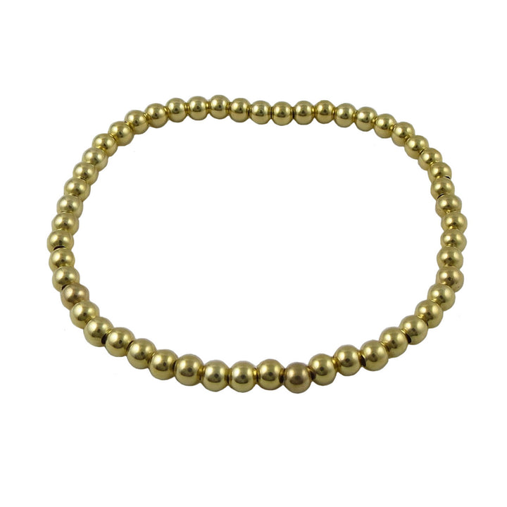 Gold beaded bracelet on a white background