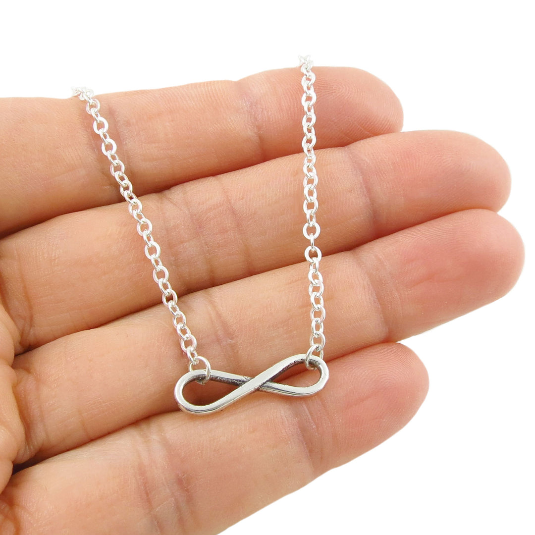 Sterling 925 silver chain bracelet featuring a large figure of eight infinity symbol design held in a person's hand.