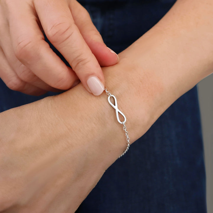 A large infinity symbol 925 sterling silver chain bracelet worn by woman 