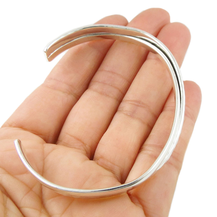 Sterling 925 Silver oval bracelet held in a hand against a white background