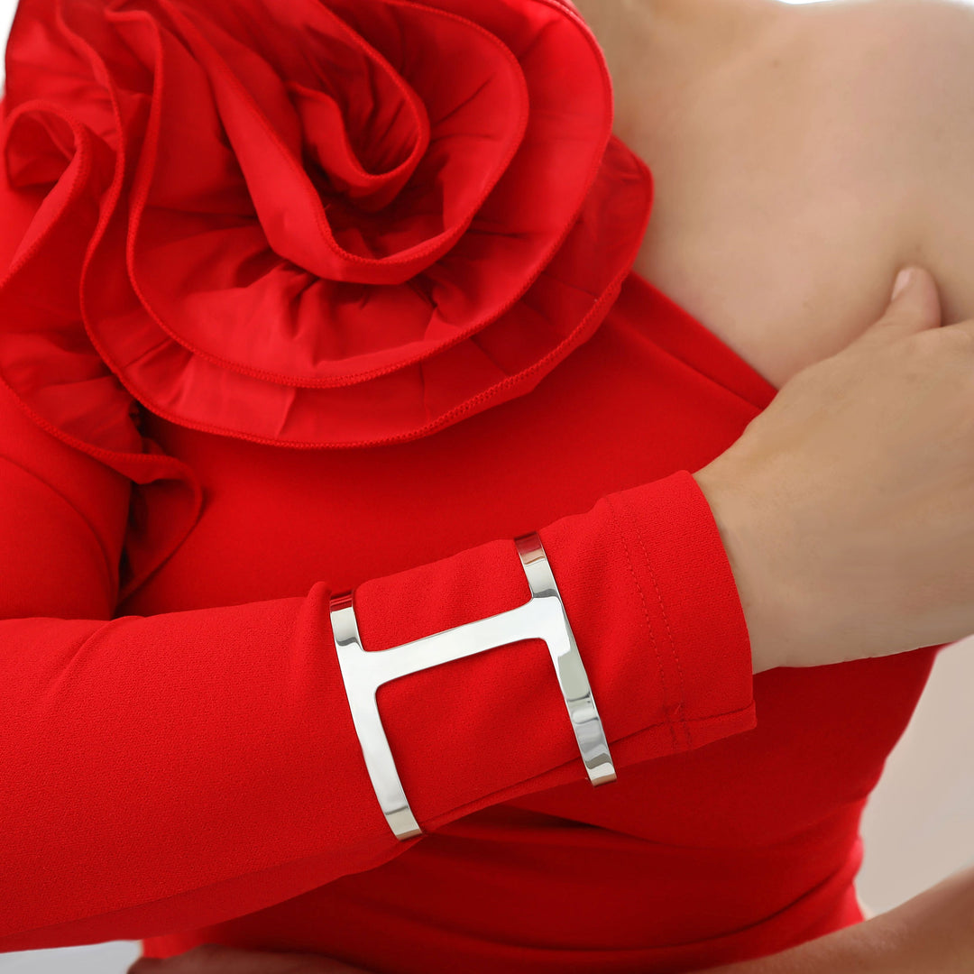 A woman wearing a red dress with a wide sterling silver bracelet cuff