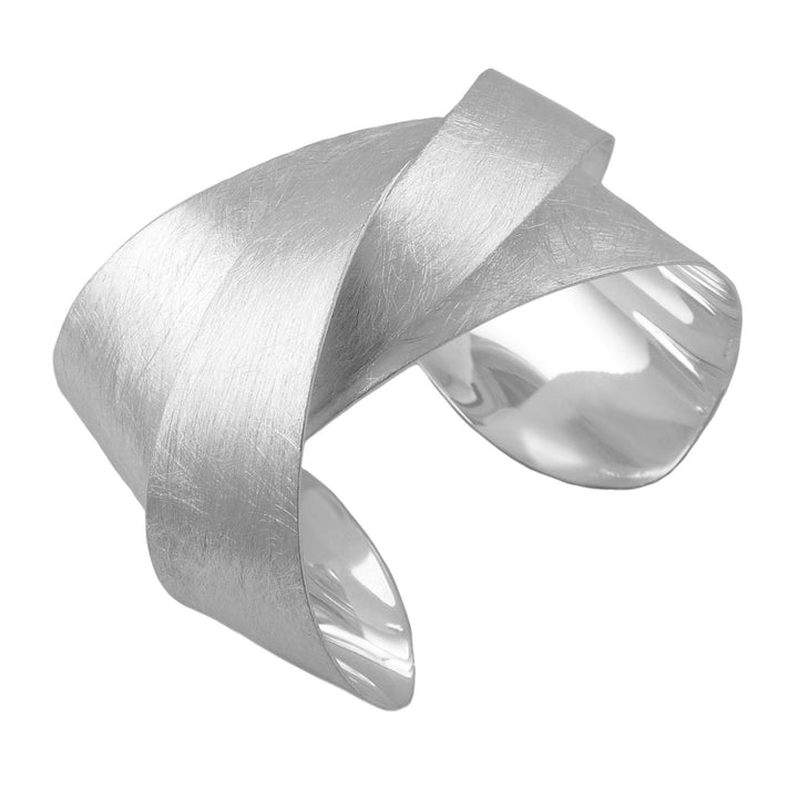 Silver knotted bracelet with a textured surface on a white background