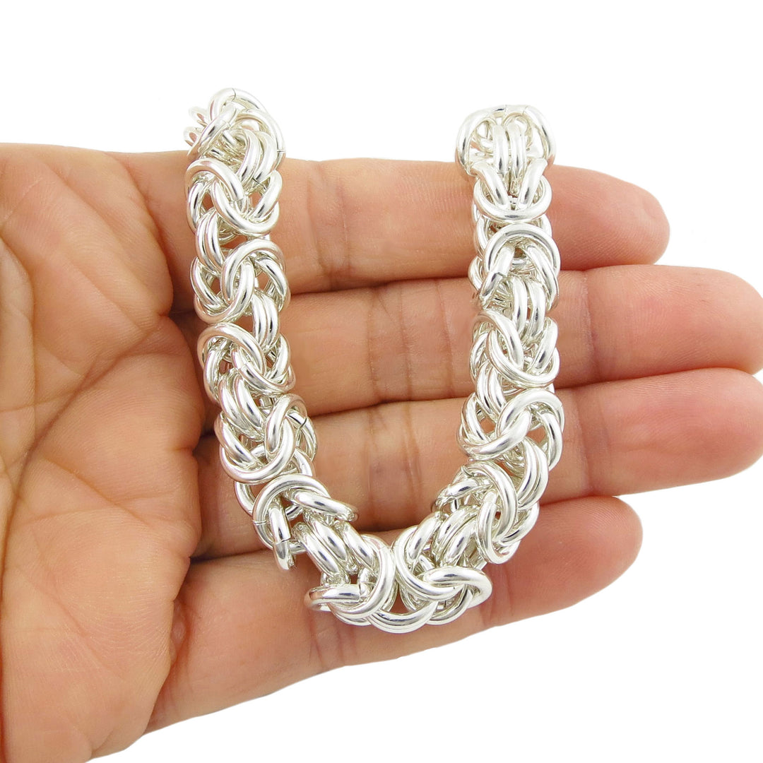 Byzantine chunky sterling 925 silver chain bracelet held in a hand against a white background