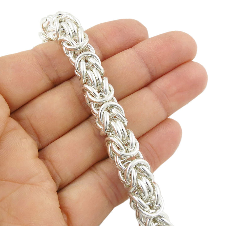Sterling 925 silver heavy byzantine chain bracelet held in a hand against a white background