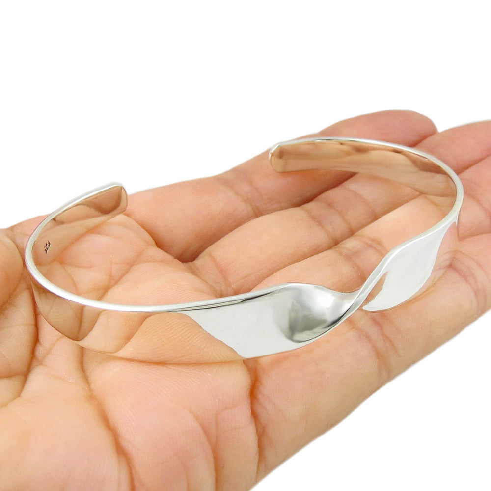 Large Taxco sterling 925 silver spiral bracelet on a hand against a white background