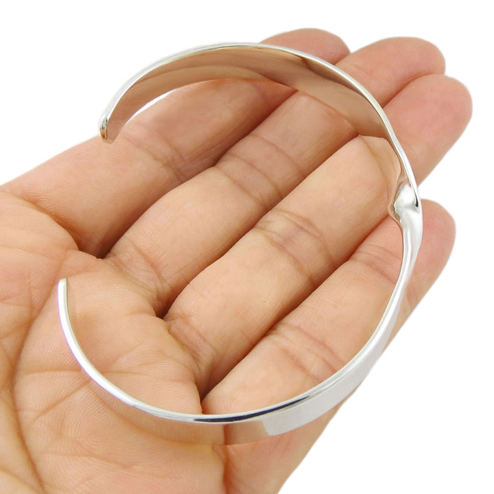 Large sterling 925 handmade silver bracelet on a hand against a white background