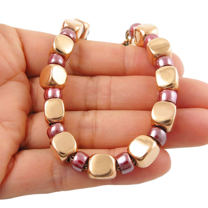 Chunky copper square bead bracelet for women on a hand against a white background