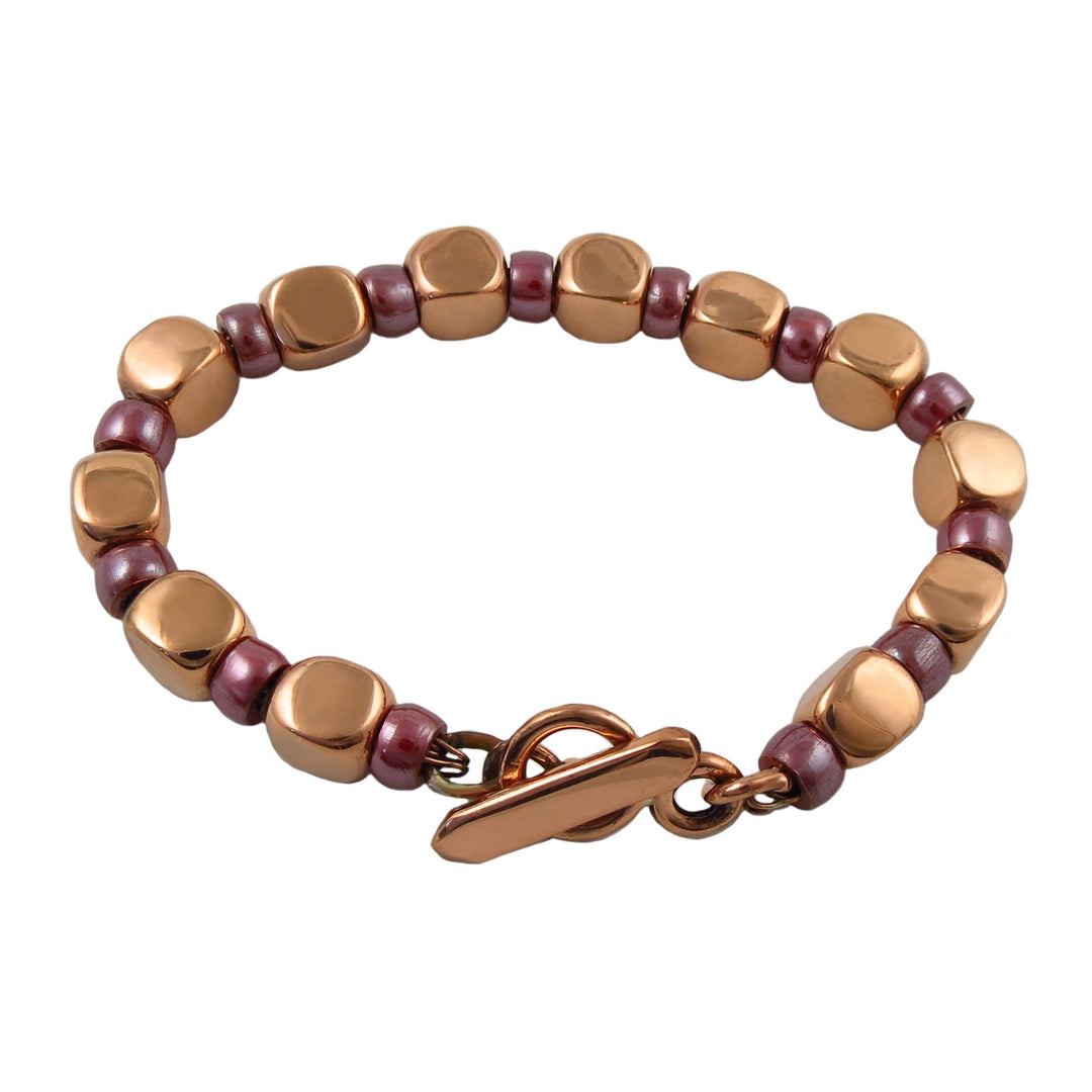 Large chunky square link bracelet with copper and wood spacer beads on a white background
