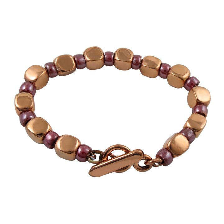 Large chunky square link bracelet with copper and wood spacer beads on a white background