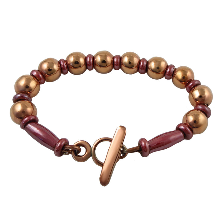 Bracelet for women with copper ball beads and rose pink spacers on a white background