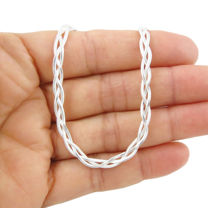 UK hallmarked Sterling 925 Silver braided triple snake chain necklace held in a hand against a white background