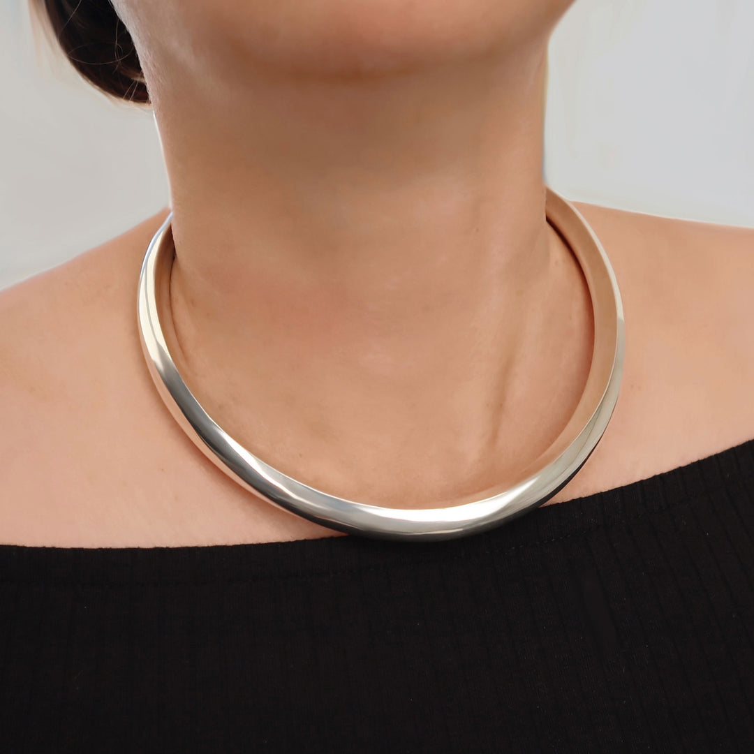 Chunky sterling 925 silver choker necklace worn by a woman on a plain background