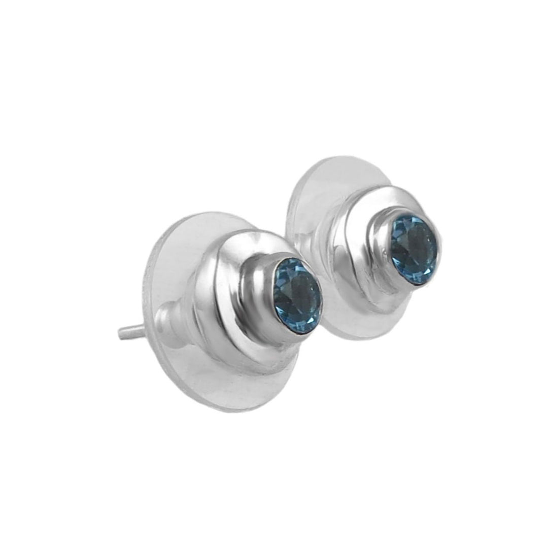 Silver earrings with blue topaz gemstones on a white background