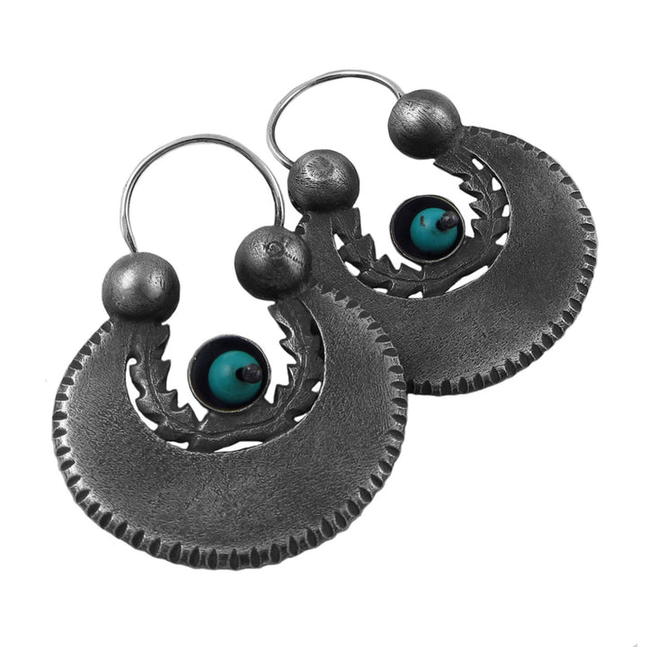 Pair of blackened 925 sterling silver earrings with natural turquoise gemstones on a white background