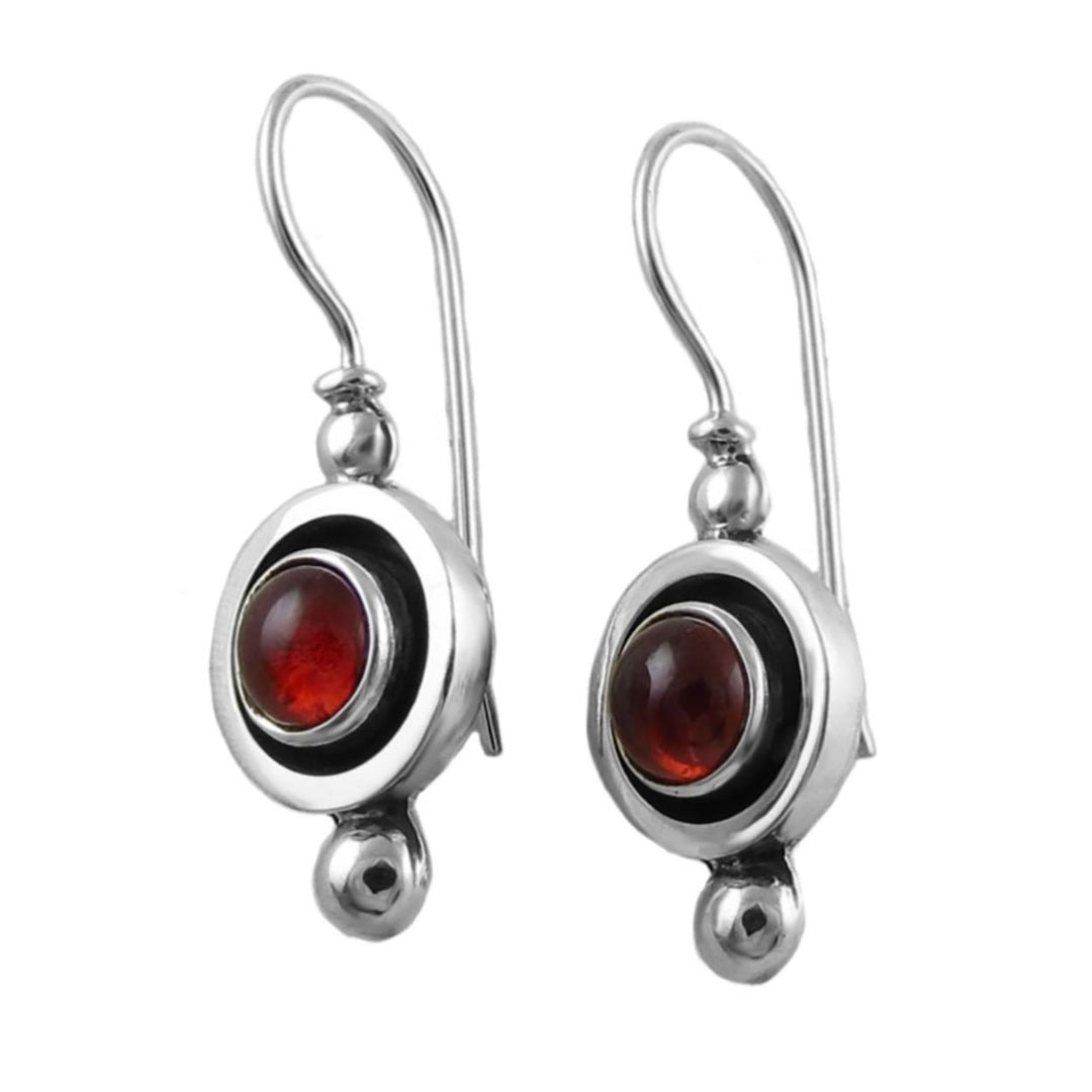 Silver earrings with red garnet gemstones on a white background