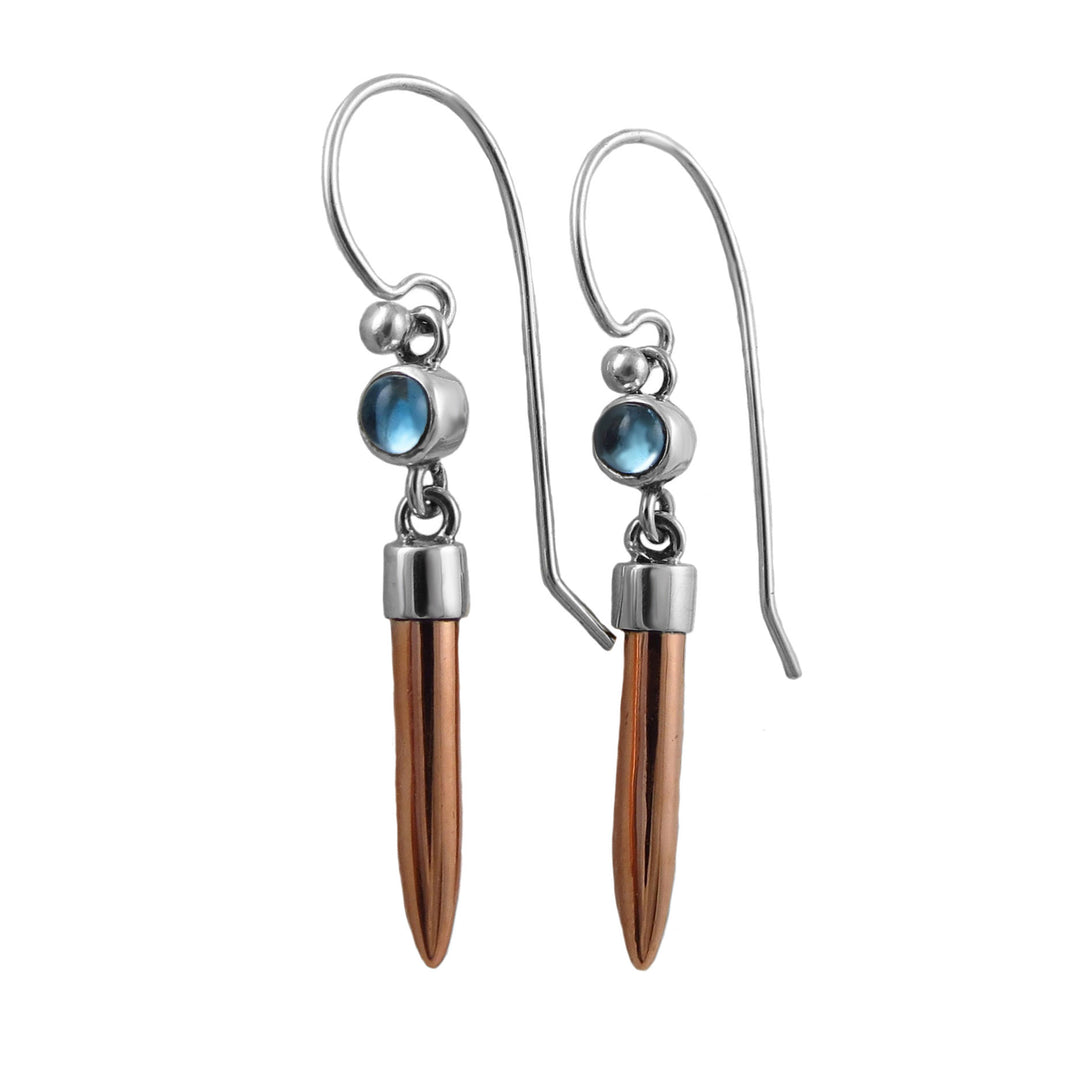 Mixed metal silver and copper drop earrings with blue topaz gemstones on a white background. 