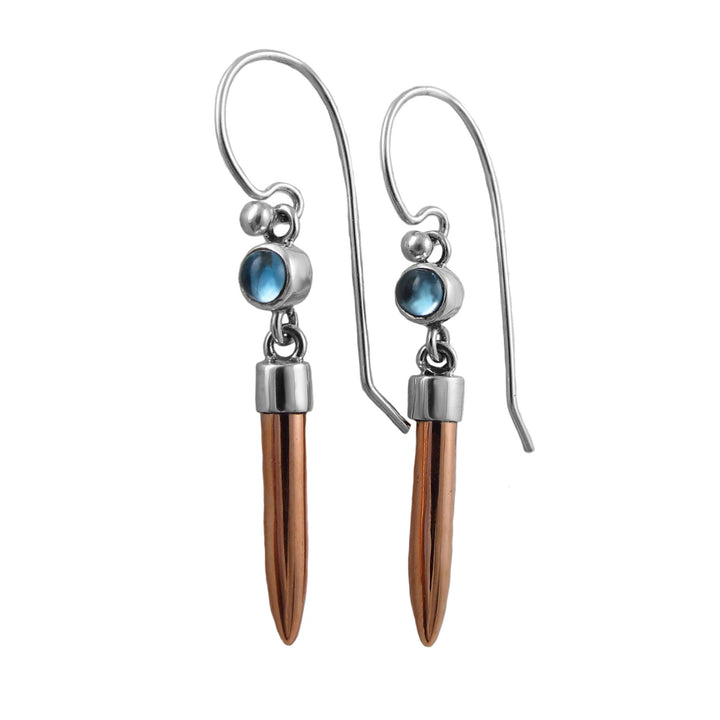 Mixed metal silver and copper drop earrings with blue topaz gemstones on a white background. 