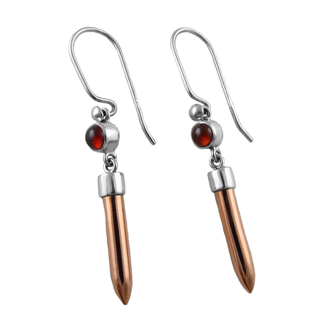 Pair of mixed earrings with copper tips and red garnet gemstones on a white background. 