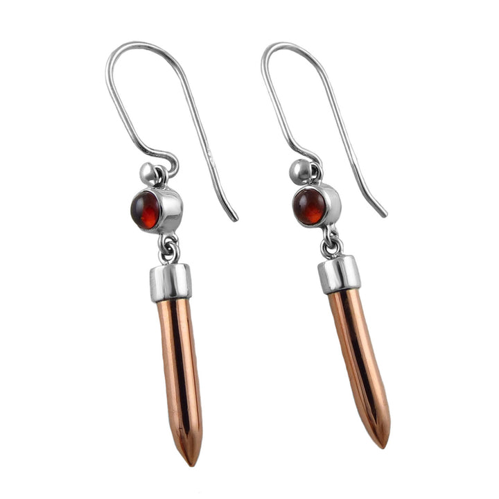 Pair of mixed earrings with copper tips and red garnet gemstones on a white background. 