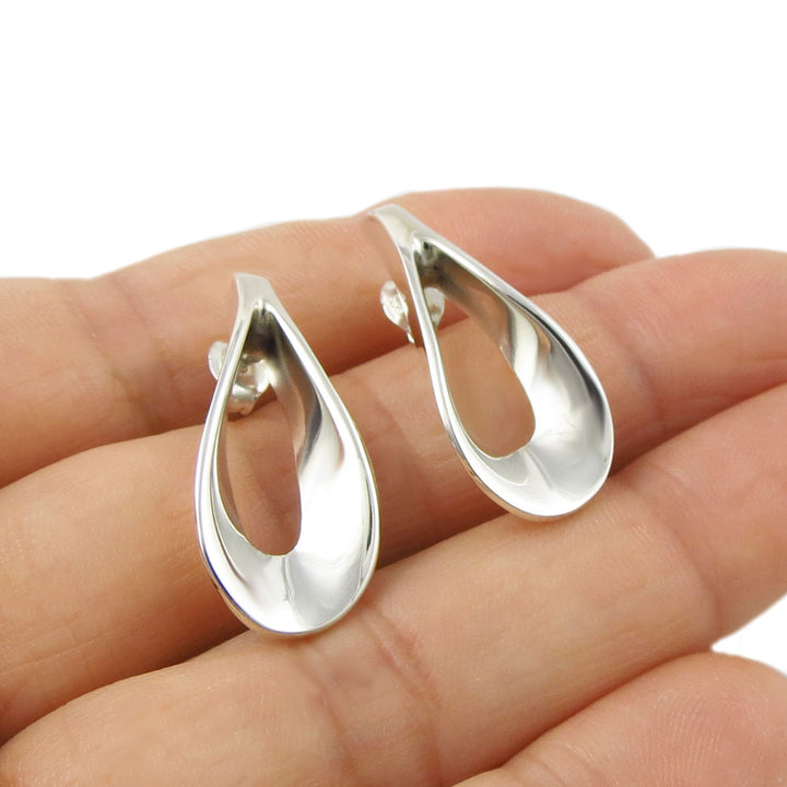Handmade 925 solid silver earrings UK held between fingers on a white background