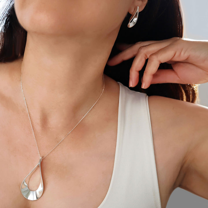 Close-up of a woman wearing a handmade artisan silver necklace with a teardrop pendant.