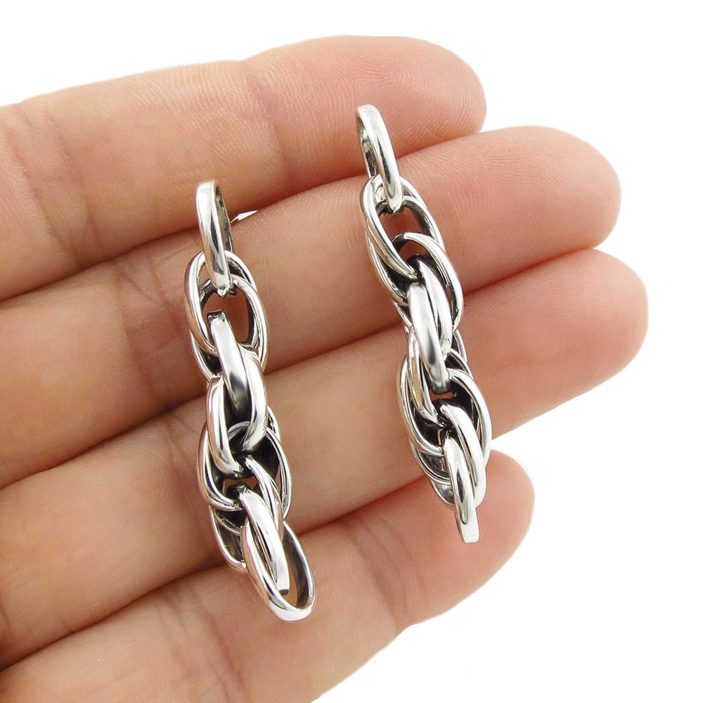 Heaby 925 sterling silver braided triple link rope chain earrings held between fingers on a white background